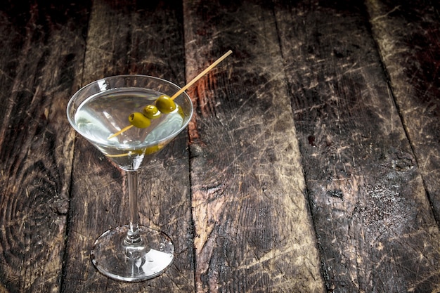 Martini with olives. On a wooden background.