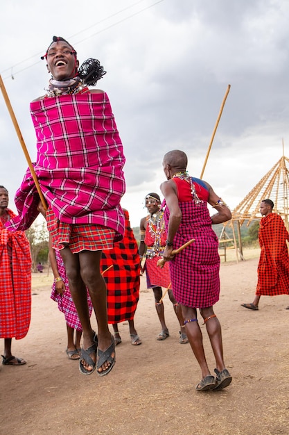 Фото Масаи в традиционной красочной одежде показывают танец прыжков масаи в деревне местного племени