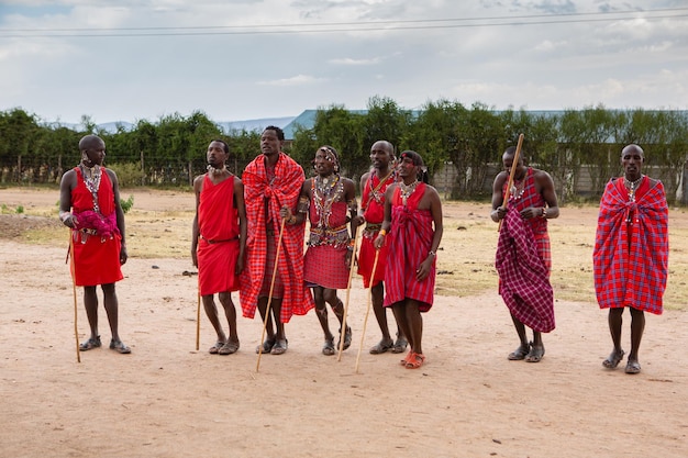 Masai in abiti tradizionali colorati che mostrano la danza del salto maasai nel villaggio della tribù locale