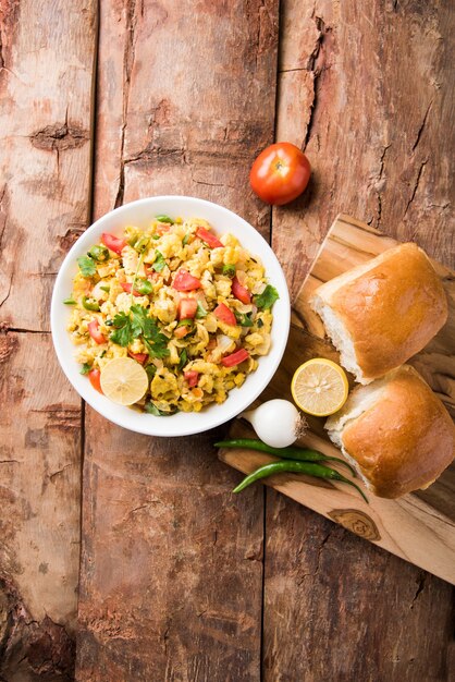 Masala Anda Bhurji of pittige Indiase roereieren met geroosterd brood of broodje of pav, populair straatvoedsel in Mumbai. Geserveerd in wit servies op een humeurige achtergrond. selectieve focus