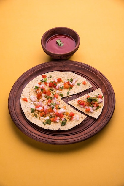 Masala papad is een Indiaas vegetarisch krokant gerecht of voorgerecht dat heel gemakkelijk te maken is. Geserveerd met tomatenketchup over humeurige achtergrond. Selectieve focus