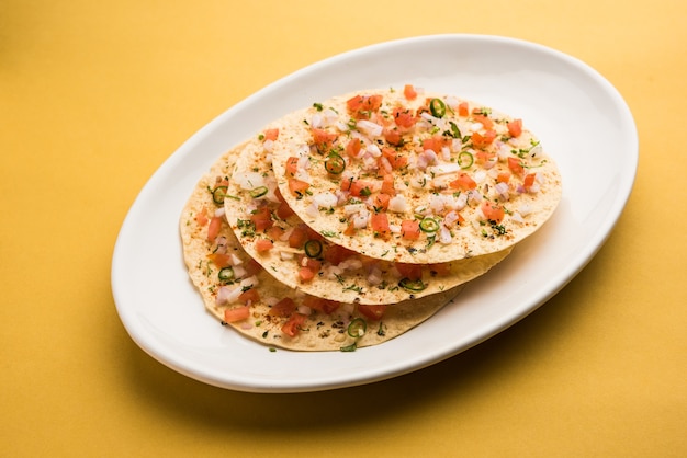 Masala Papad orÃÂ papadumÃÂ is a delicious Indian snack made using roasted or fried papad topped with a tangy and spicy onion tomato mix