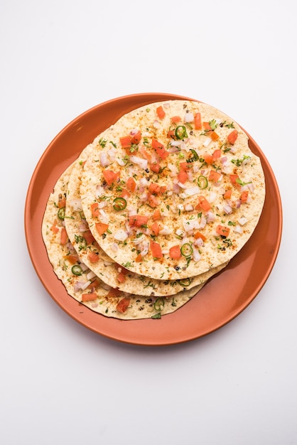 Masala Papad orÃÂ papadumÃÂ is a delicious Indian snack made using roasted or fried papad topped with a tangy and spicy onion tomato mix