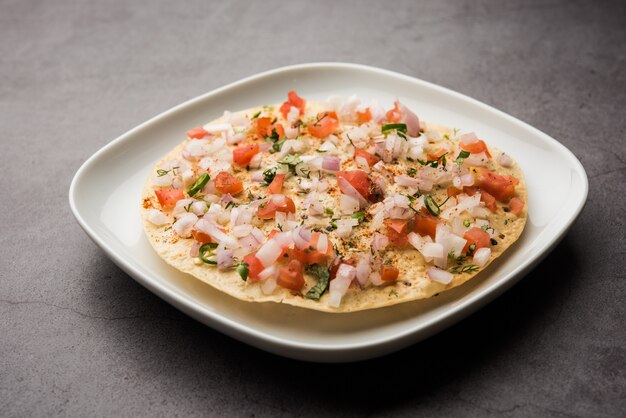 Masala Papad orÃ papadumÃ‚Â is een heerlijke Indiase snack gemaakt met geroosterde of gefrituurde papad gegarneerd met een pittige en pittige uien-tomatenmix