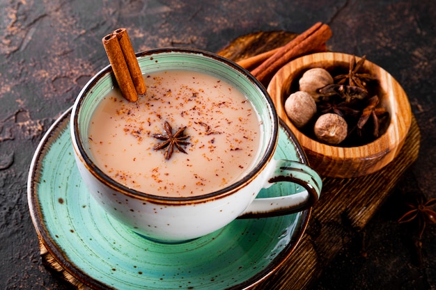 Masala tea indian traditional tea with milk and spices in a cup close up