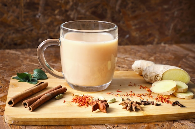 Photo masala tea . invigorating tea with spices, ingredients on the board. dark texture background.