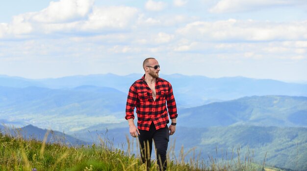 Masculine power tourist walking mountain hill power of nature\
man stand on top of mountain landscape background hiking concept\
discover world masculinity and male energy natural power