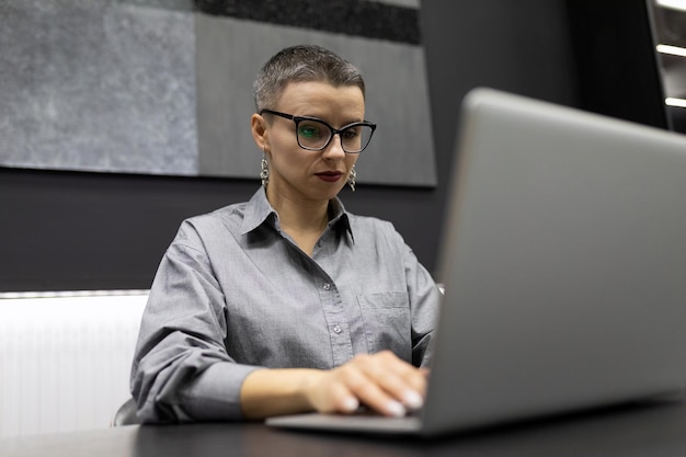 강한 사무실에서 노트북 작업을 하는 짧은 머리를 가진 남성 여성 프로그래머