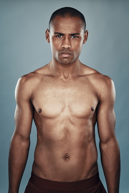 Masculinity. Shirtless young African man looking at camera while standing against grey background