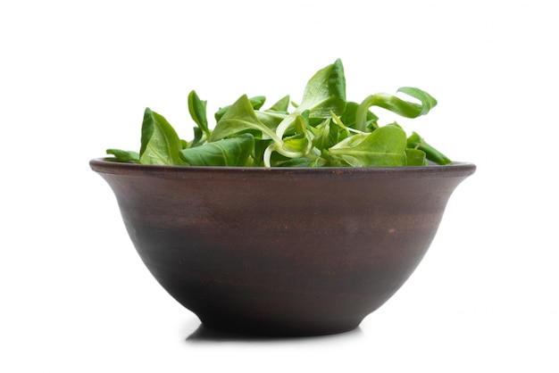 Mash salad in ceramic brown bowl isolated on white