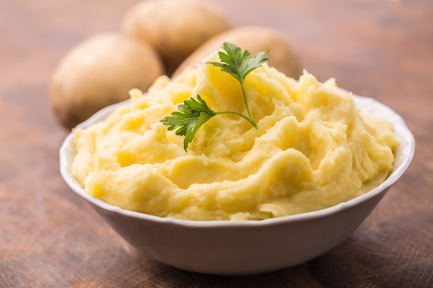 Mashed potatoes in bowl decorated with parsley herbs.