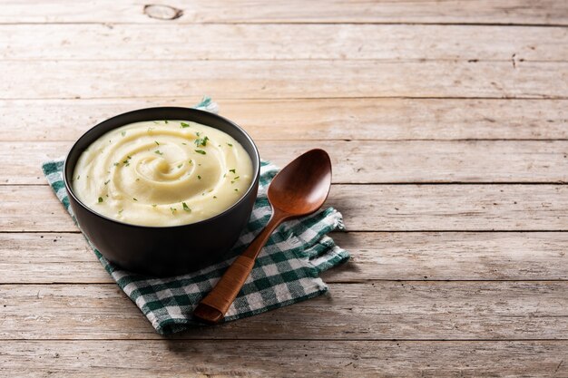 Mashed potatoes in a bowl on wooden table