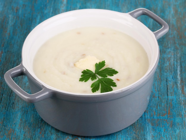 mashed potatoes in saucepan on blue wooden table