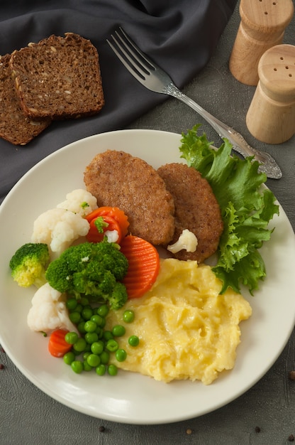 マッシュポテトとカツレツ、蒸し野菜と穀物パン