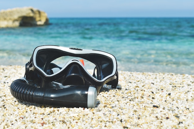 Photo mask for diving on the sand against the sea