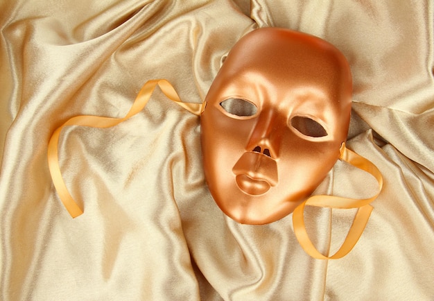 Mask on gold fabric background