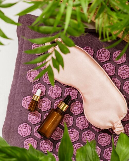 Mask for sleep dropper bottles on massage mat with home plants