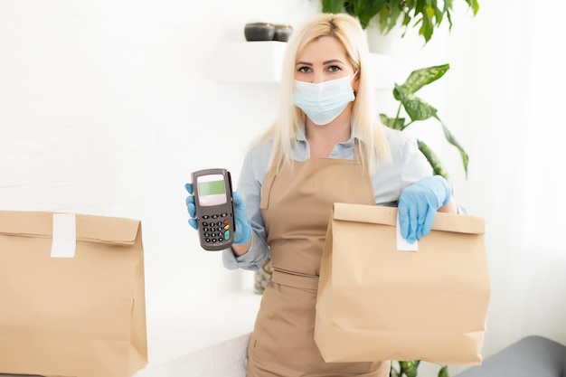 masked blonde girl with pos terminal.