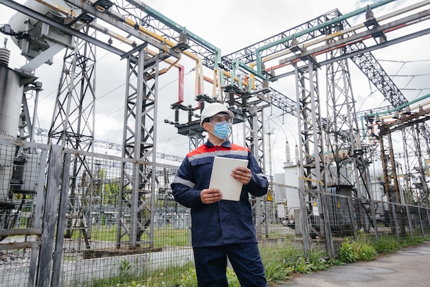 Masked engineer inspects an electrical substation