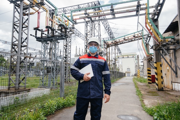 Masked engineer inspects an electrical substation