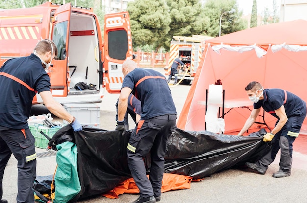 Foto vigili del fuoco mascherati preparano il tunnel di decontaminazione per il covid 19