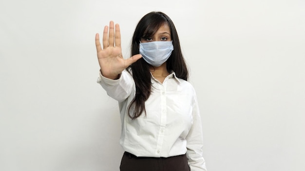 The masked Indian woman makes stopping hand gesture in COVID time