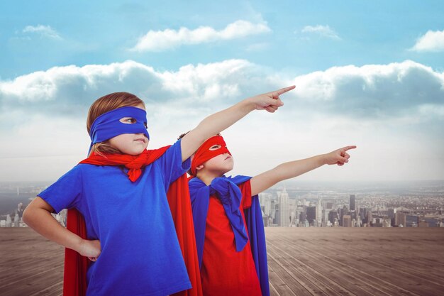 Photo masked kids pretending to be superheroes against city on the horizon