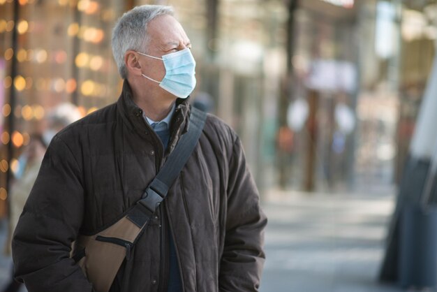 Masked man walking outdoor to go at work coronavirus people lifestyle concept