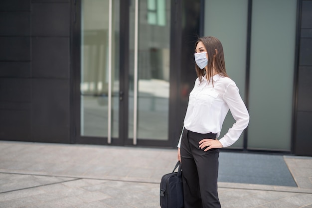 Masked woman walking in a city park