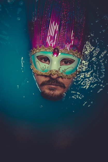 Masker, man ondergedompeld in blauw water, concept van depressie