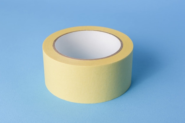 Photo masking tape for preparing the room before painting the walls. paint tool (painter's tape) on a blue background