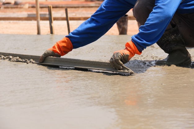 Foto mason die een cement van de dekverflaag op het vloerwerk bouwt