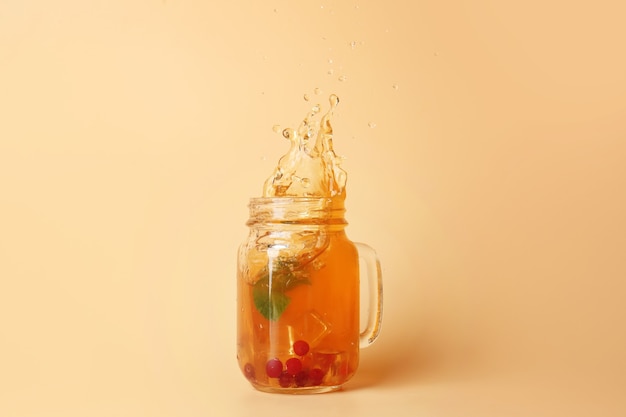 Mason jar koude thee met spatten op kleur