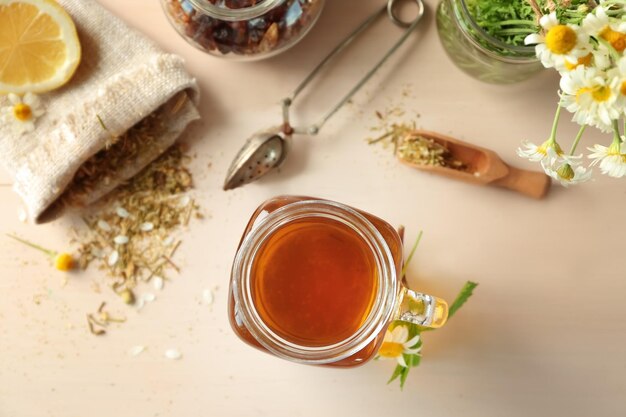 Mason jar met lekkere kamille thee op lichte houten tafel