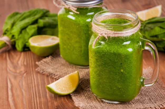 Mason jar mokken gevuld met groene spinazie en boerenkool gezondheid smoothie
