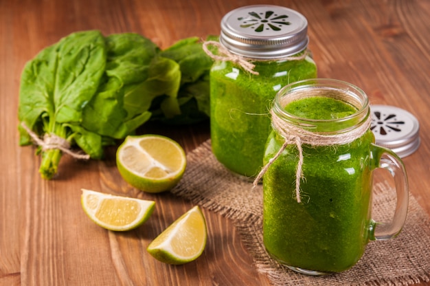 Mason jar mugs filled with green spinach and kale health smoothie