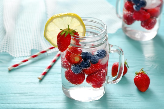 Mason jar with delicious strawberry lemonade on wooden table