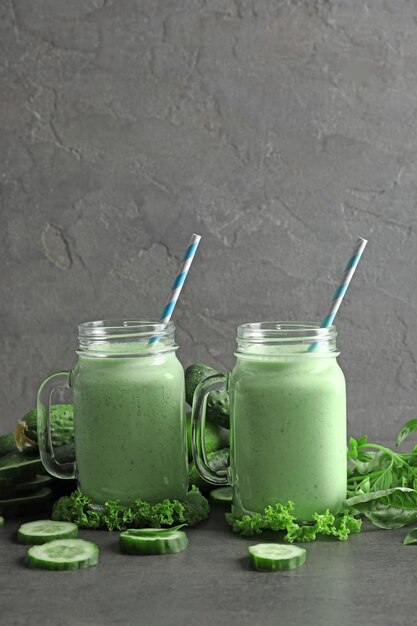 Foto mason jars met verse smoothie en groenten op tafel