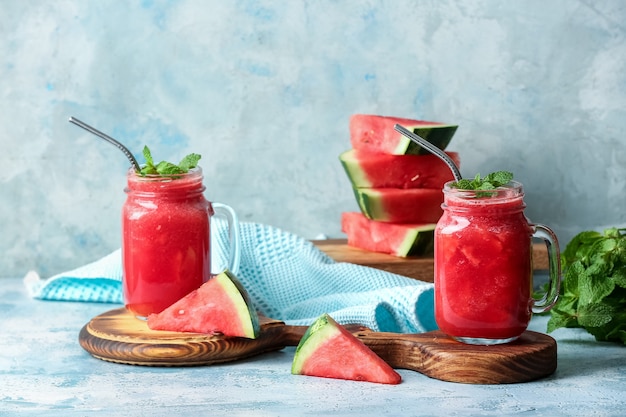 Mason jars with fresh watermelon juice on color space