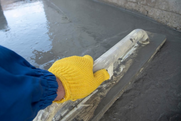 Photo mason leveling and screeding concrete floor base