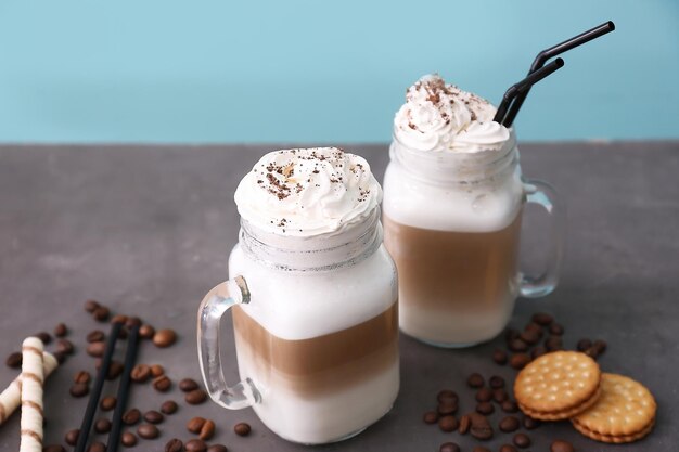 Mason-potten met latte macchiato op grijze tafel