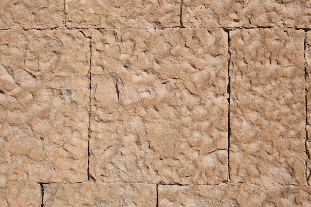 Masonry walls of natural sand color stone texture closeup\
construction and mining background