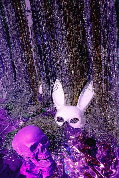 Masquerade fashion rabbit mask and skull on tinsel background.\
new year\'s clubbing mood. 80s disco vibes. halloween, party\
concept