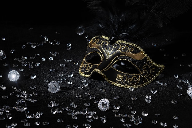 Photo masquerade gold mask with gemstones on black background