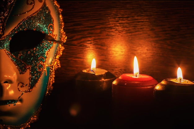 Masquerade mask and candles on a black background