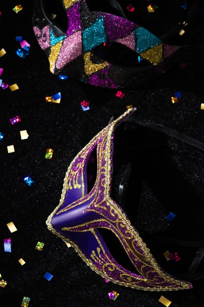 Masquerade mask with confetties on black background