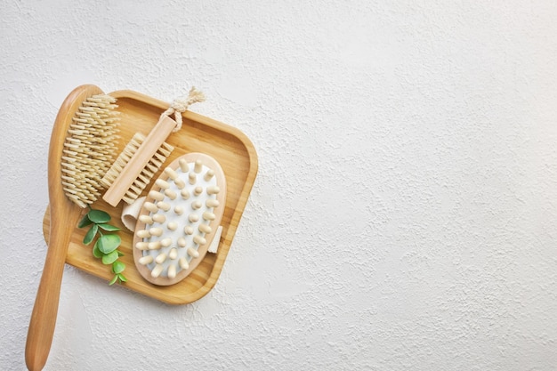 Massage bath set of bamboo brushes on a wooden tray