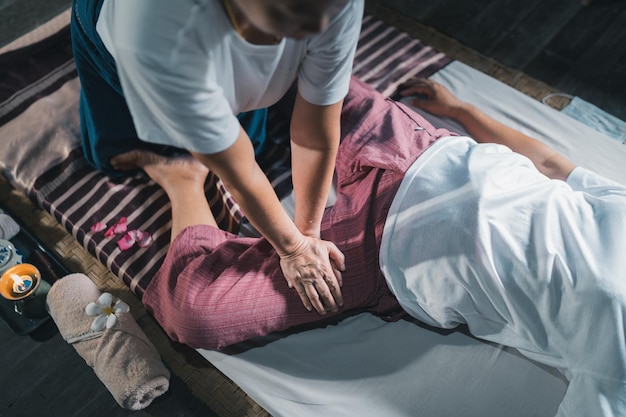 Foto massage en spa ontspannende behandeling van kantoorsyndroom traditionele thaise massagestijl asain senior vrouwelijke masseuse die massage doet behandel hand rugpijn armpijn voet en stress voor oude vrouw moe