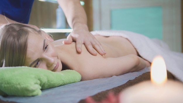 Massage parlor - young girl gets relaxing healing therapy, close up