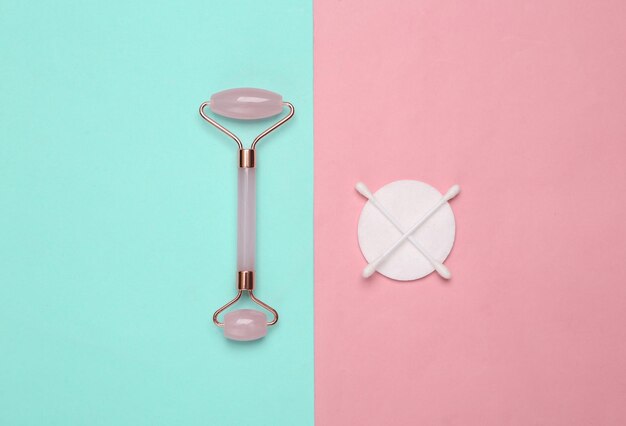 Massage rol katoenen pads met stokken op blauwe roze achtergrond Top view